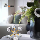 Crystal Ball Molecular. In a room with an armchair and a coffee table. It has a potted plant and next to it is Crystal Ball Molecular; Vibe Houses.