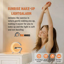 Clock  Alarm - Little G; Bluetooth wireless stereo with multiple lighting modes; white; woman stretches sitting on bed; SUNRISE WAKE-UP
LIGHTGALARM; Imitates the sunrise innature, gently waking you up,
making it easier for you to wake up and the light is soft and not dazzling; 12/24 Hour Modes, Dual Alarm, Natural Sounds, Wireless Charging; vibe houses