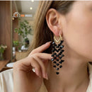 Black Crystal Earrings – Modern and Elegant Style. Woman with her face turned to the side, highlighting the black crystal earring in her ear; vibe houses