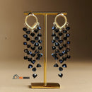 Earrings with black crystal tassel pendant ✨ earrings displayed on a gold stand; vibe houses