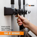 Organize your space with our broom holder. Multifunctional. A person hangs a feather duster. Five slots. six hooks. zero clutter. tons of sotorage; vibe houses