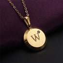 Pendant necklace. Initial AZ - Semi jewel. 18k gold plated. Dark image background with the golden necklace highlighted. Letter W; vibe houses

