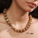 Necklace | Terra Gold - Brown Coffe color. Woman wearing it around her neck. Enlarged image; vibe houses
