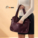 Margaret - Shoulder or handbag in soft leather - woman opens the back compartment of the bag with one hand; vibe houses