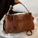 Solea Bag - Brown, One hand holds the bag by the handle vibe houses