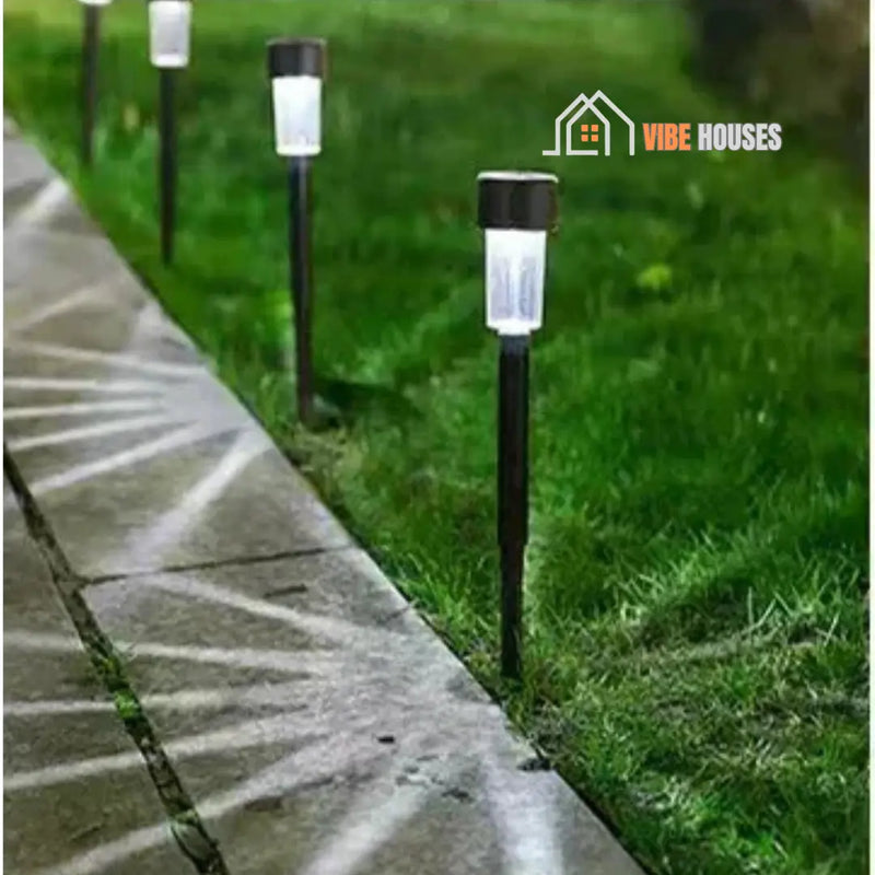 Solar-powered garden lights; Image of four Black Shell-Whites sticking in the lawn. Vibe Houses