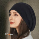 CozyMuse women's beanie. Woman with her face turned to the side, looking upwards, wearing a black beanie. vibe houses