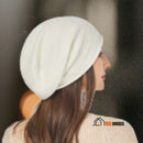 CozyMuse women's beanie. Woman with her back turned. She is wearing a white beanie. vibe houses