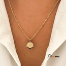 Necklace with alphabet pendant, letter (M); Enlarged image, woman wearing it around her neck; vibe houses